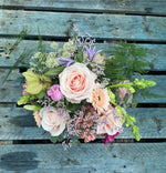Pink and cream flowers that include roses in what could be a pink hat box that would be an ideal gift for Mother's Day